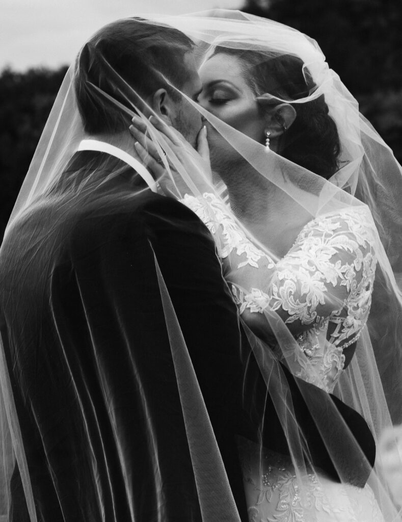 Bride and groom kissing under veil. Classic wedding photos. Candid wedding photos. Classic wedding photographer. Boston wedding photographer. 