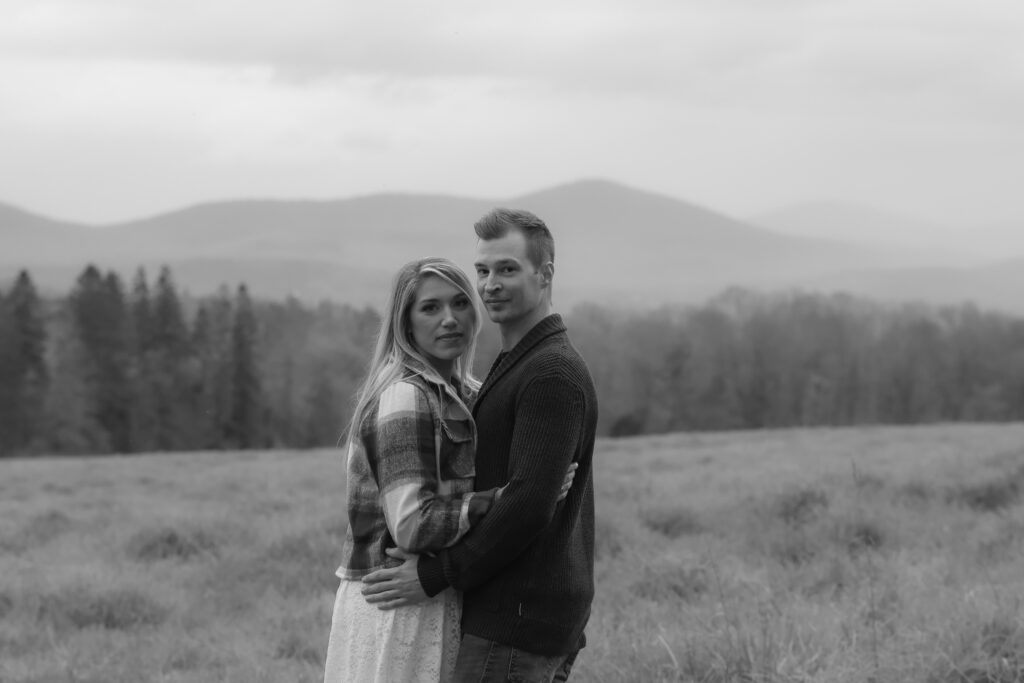 Couple posing for their engagement session overlooking the Green Mountains in Vermont. Elopement in Vermont. Intimate ceremony ideas in Vermont.
