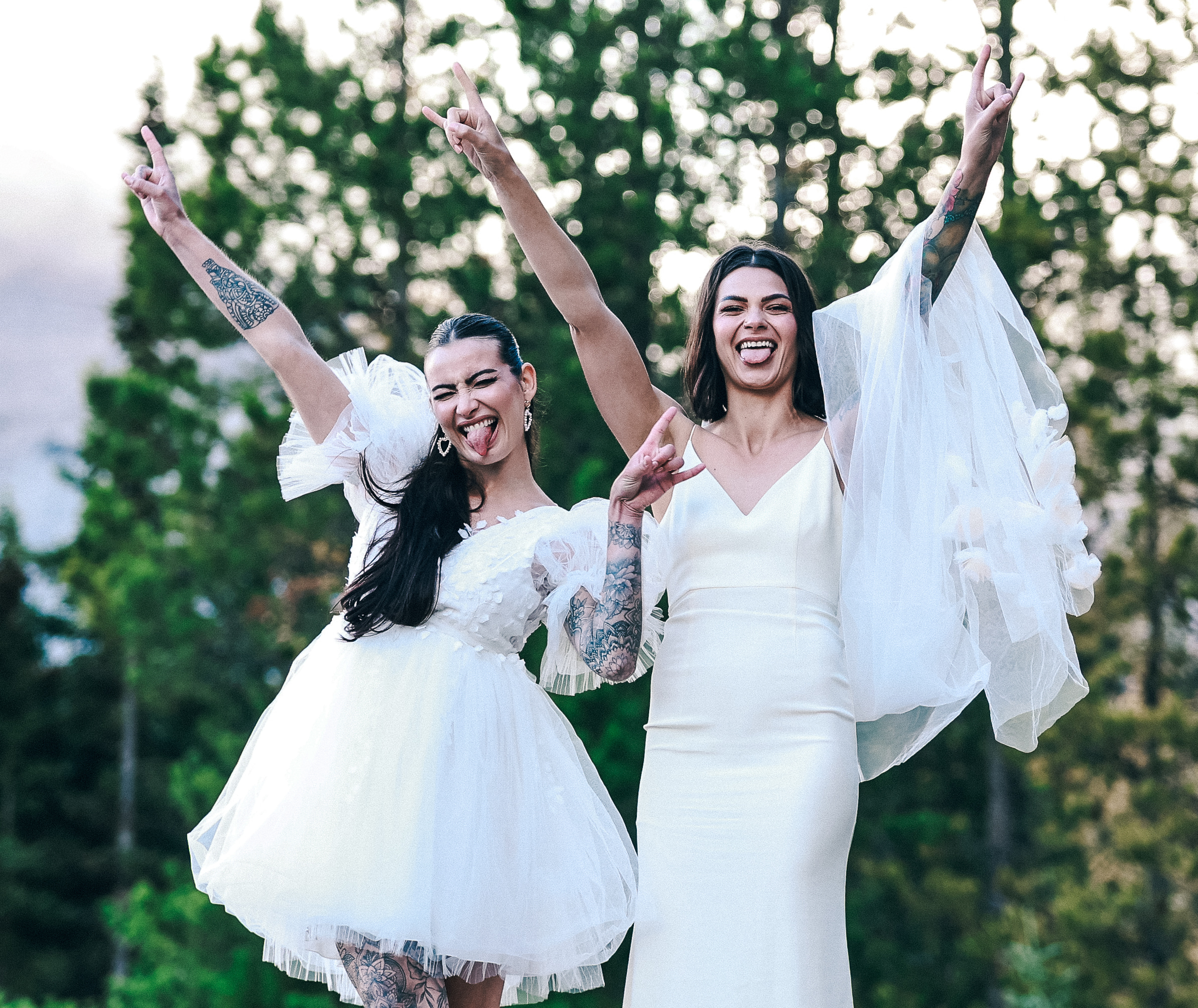 brides giving rock and roll symbol in the mountains during their elopement