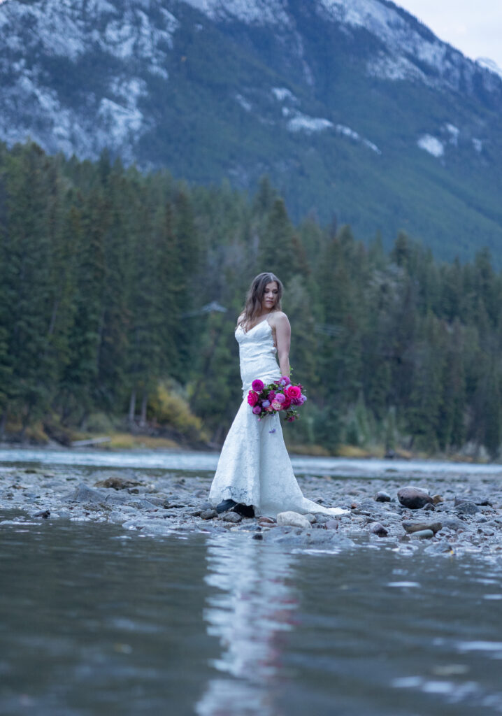 Bride posing for elopement photographer in the mountains of Banff, Canada. 